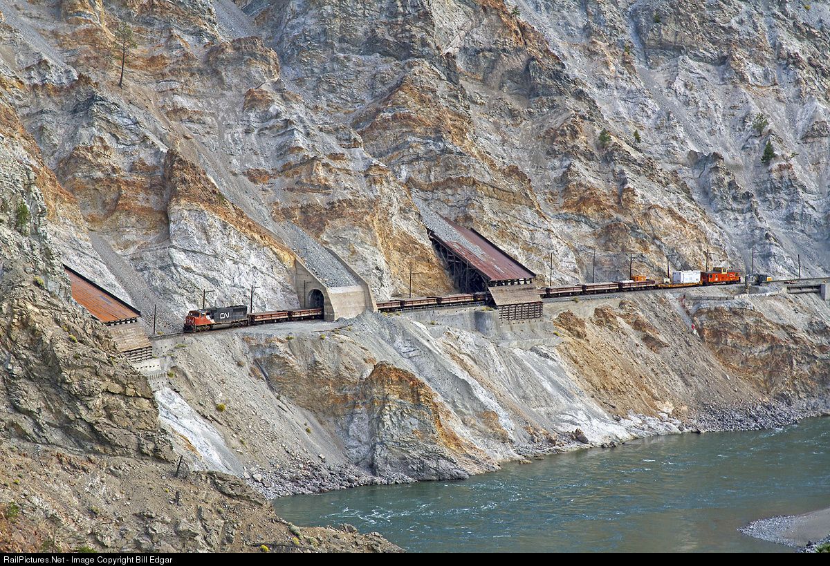 Train traveling through the Canadian Rockies with snow-capped mountains